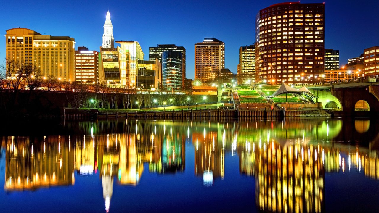 Downtown Hartford Connecticut skyline at night with city lights reflecting on the Connecticut River